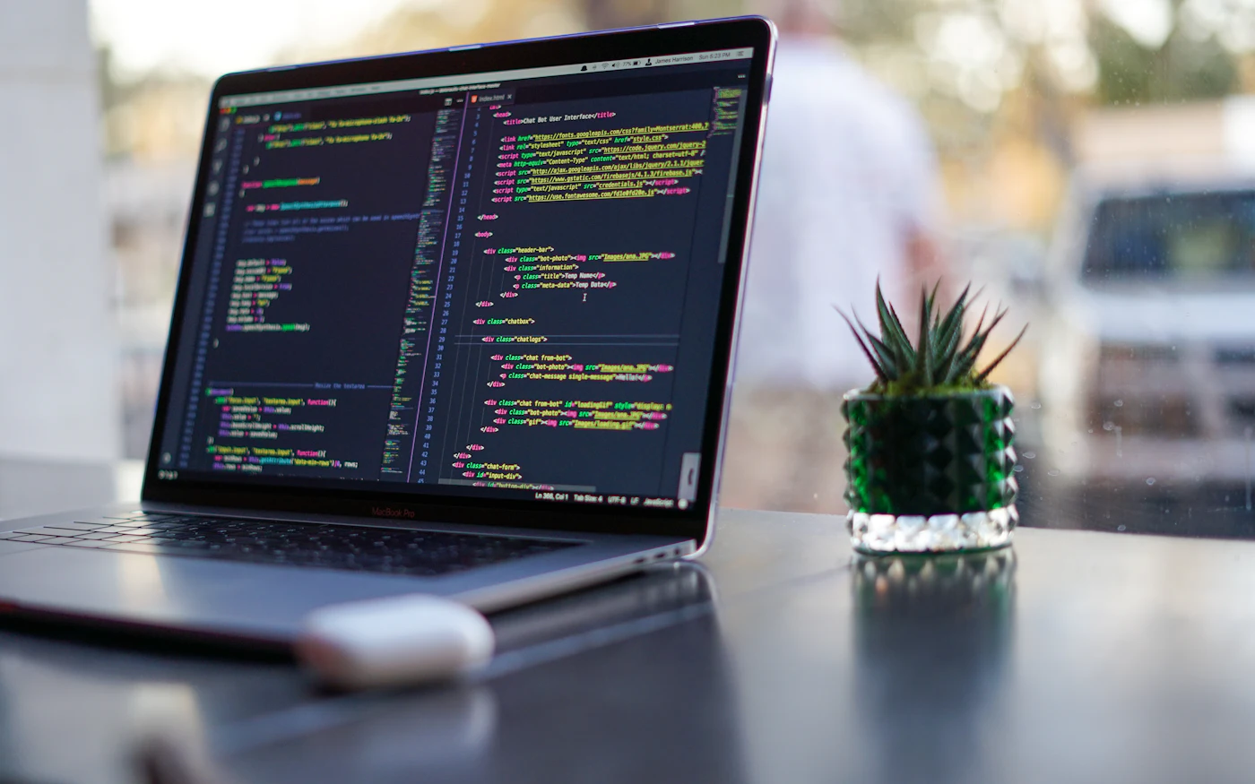 Laptop on a desk showing website source code in an editor